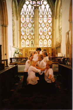 Dancers in pairs, cupping each others cheeks in their handshands